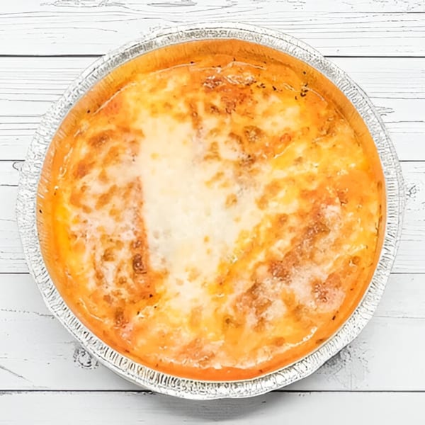 A round, baked Villa Pizza lasagna with melted cheese and sauce in a foil pan.